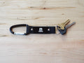 Black keychain with keys on a wooden surface