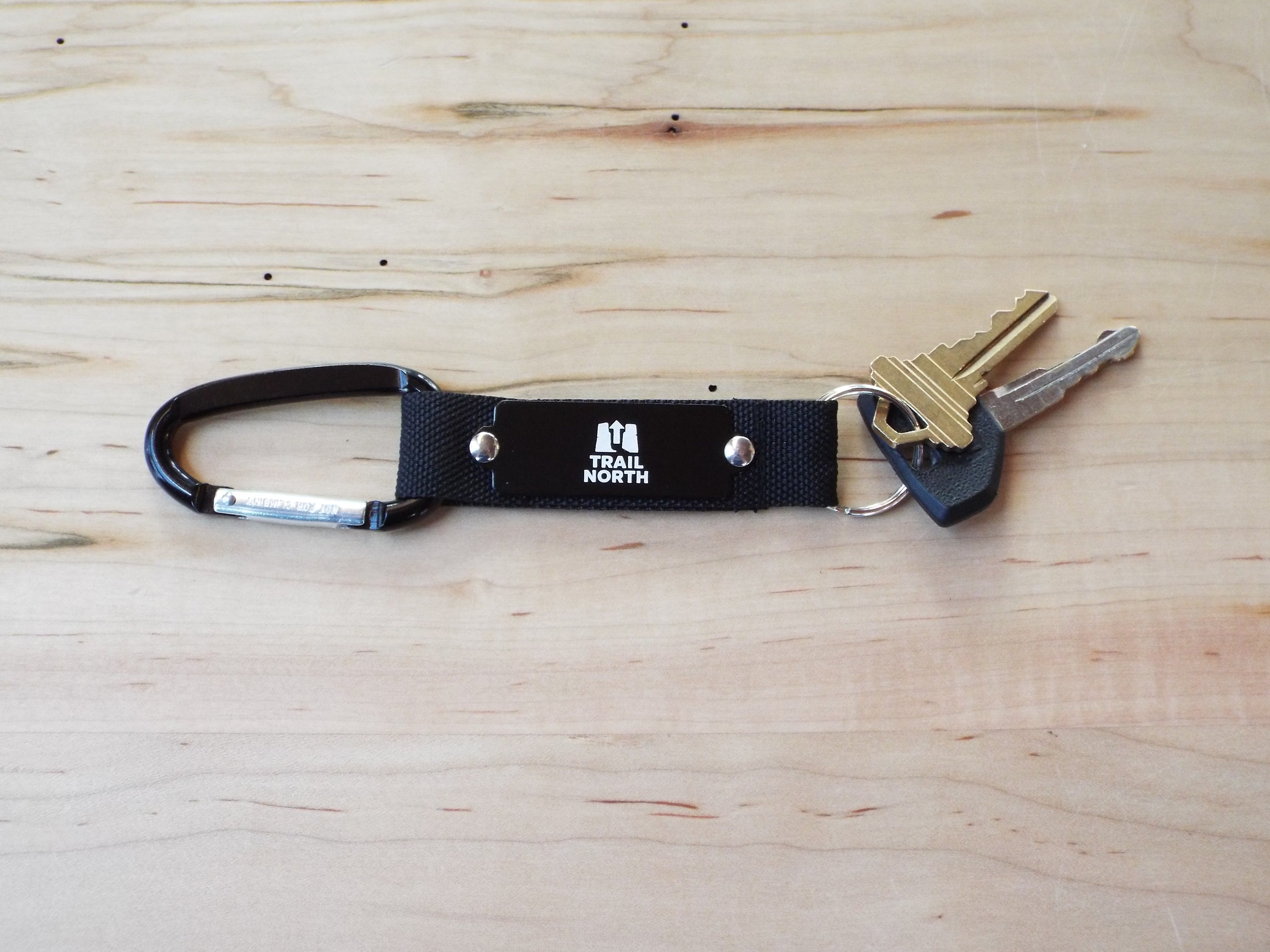 Black keychain with keys on a wooden surface