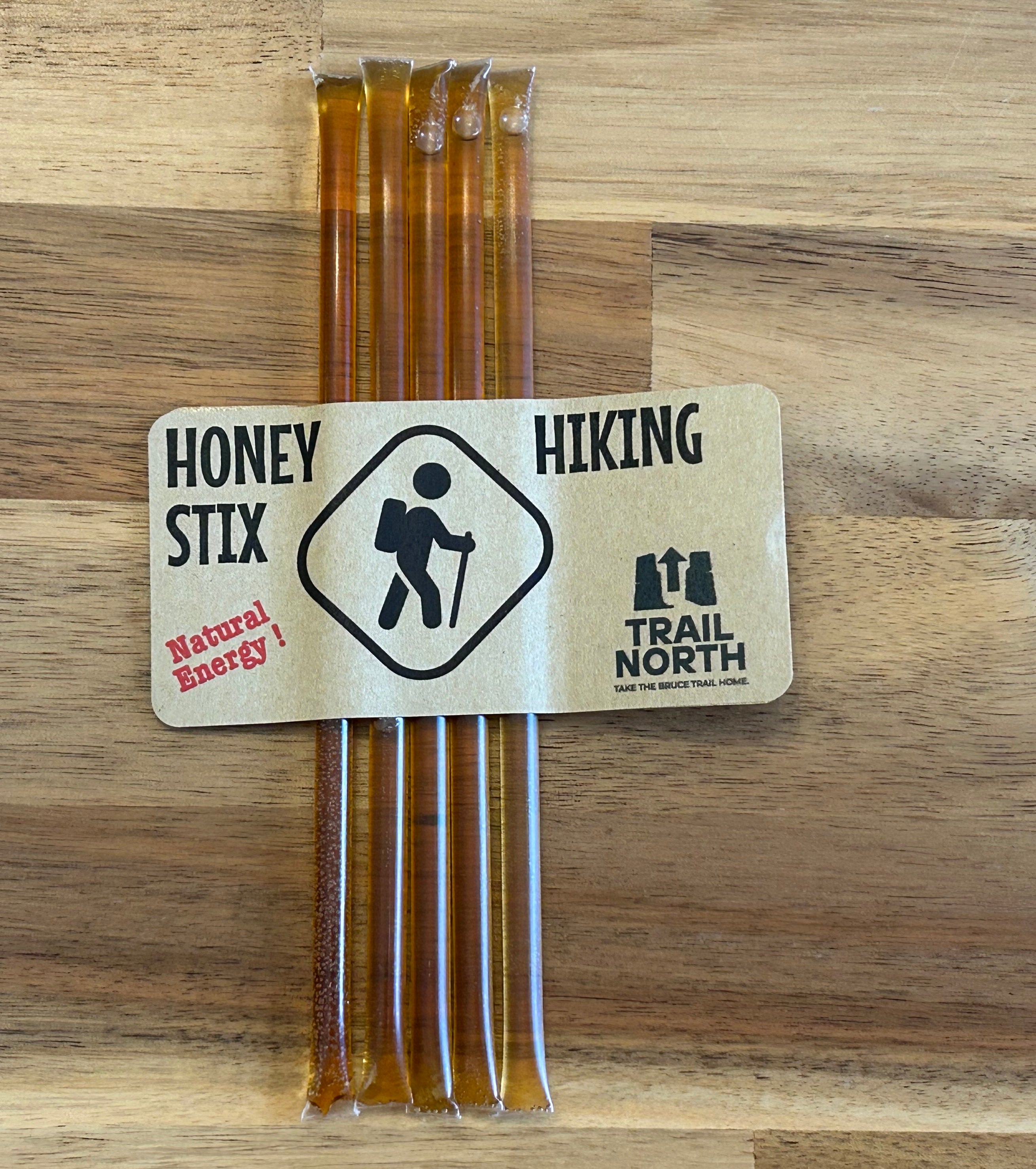 Honey Stix packaging with hiking theme on a wooden surface