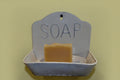 Soap dish with a bar of soap on a yellow background